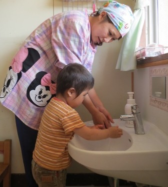 保育士と手を洗っている写真