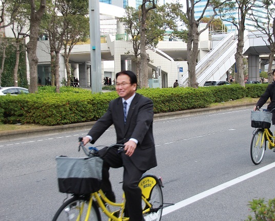 マックルの自転車で幕張新都心を走行する鈴木元局長