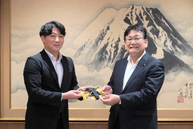 閔 代表取締役、神谷市長（手にしているのは同社製品のドローン「IBIS2」）
