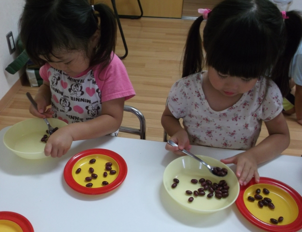 スプーンを下から握って豆を運ぶ写真