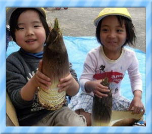 皮付きの筍を持っている写真