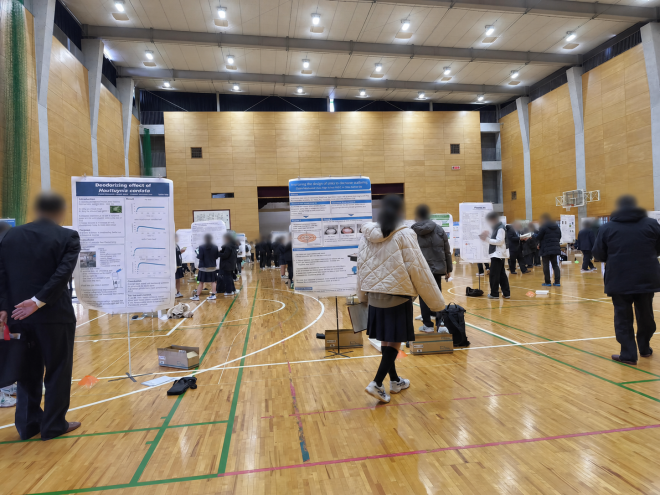 令和6年度CCSS Fairで、体育館内の発表を参加者が聞いている様子(顔ぼかし加工済み)