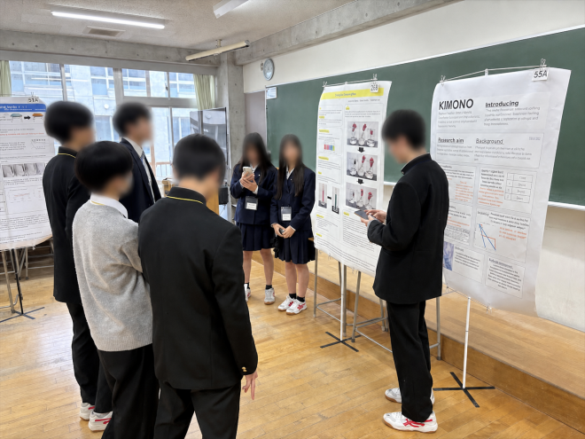 令和7年度CCSS Fairで、教室内の研究発表を参加者が聞いている様子(顔ぼかし加工済み)